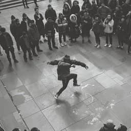 Street performer and gathered crowd in a city square.